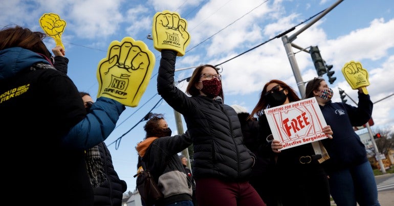 Demonstrators in New Brunswick holding signs