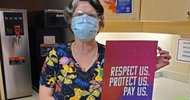 travailleuse de la santé avec pancarte contre la loi 124