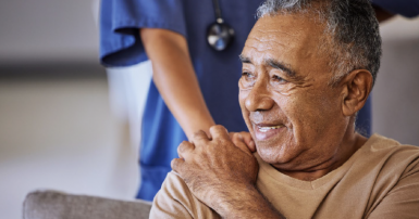 A health care workers places her hand on the shoulder of an elder