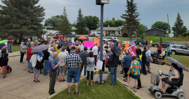 A crowd of people gathered with flags and picket signs