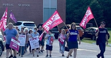 Des membres du SCFP manifestent devant une école publique