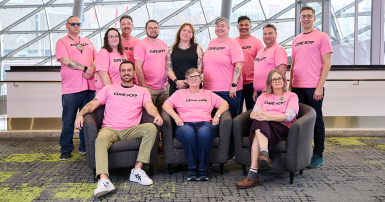 People posing for a photo wearing pink t-shirts