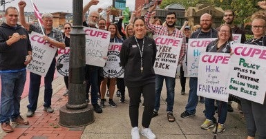 Striking workers holding picket signs