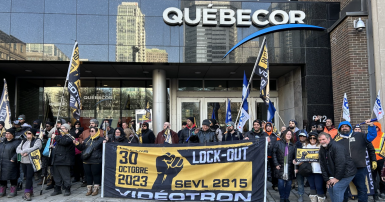 People posing for a photo with flags and signs