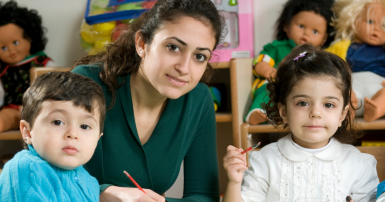 Photo of early childhood educator and two children making paintings