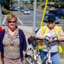 One man and two women stand with their bikes on a sunny day