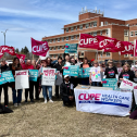 People in front of a building with signs and flags 