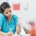 Nurse on phone with medication in hand