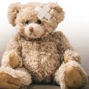 Teddy bear with a bandage and the message Save Sioux Lookout Child Care - fr