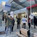People standing in front of SQDC building with picket signs