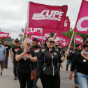 CUPE 1349 members marching with CUPE flags at a rally in Grand Falls-Windsor NL