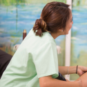 Continuing care assistant kneels and rubs the leg of a senior woman in a wheelchair