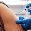 An arm being vaccinated