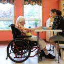 Nursing home worker with client in a wheelchair