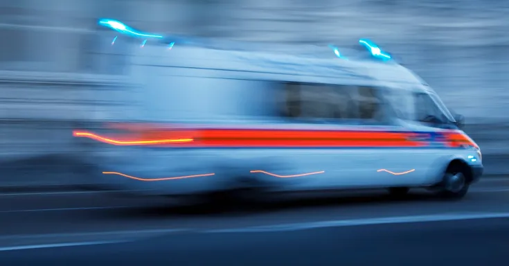 An ambulance travels so fast it is a blur