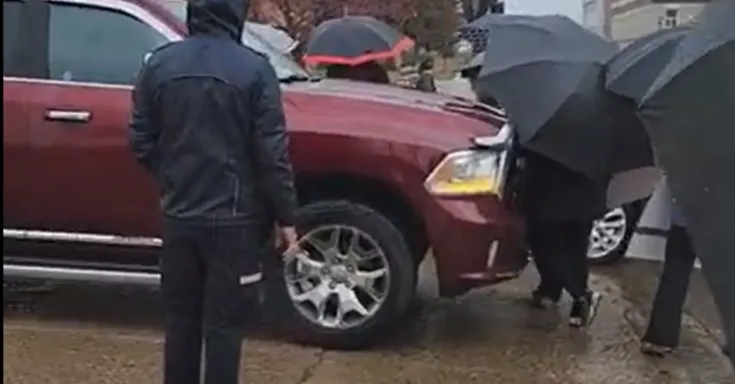 truck being driven into picketers