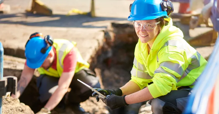 A female municipal worker does roadwork on a residential street.