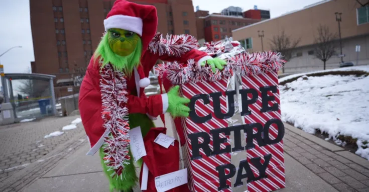 Grinch with box labelled CUPE Retro Pay