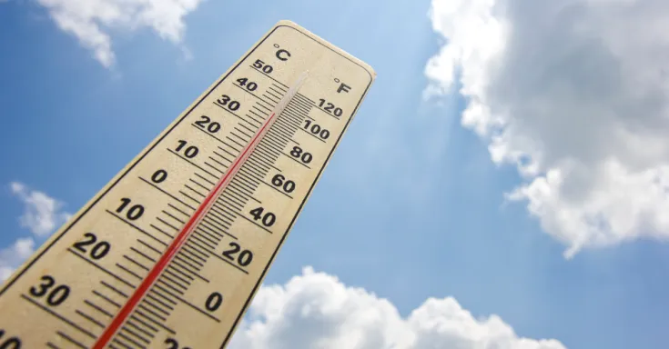 Thermometre showing 38°C against a blue sky