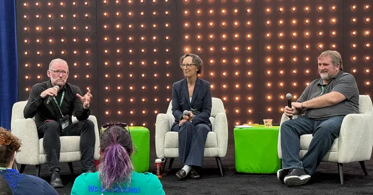 three people sitting in chairs on on a stage