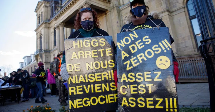 Women with picket signs at rally in Fredericton