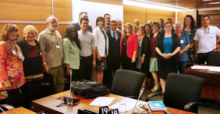 Group of people standing in a wood panelled room