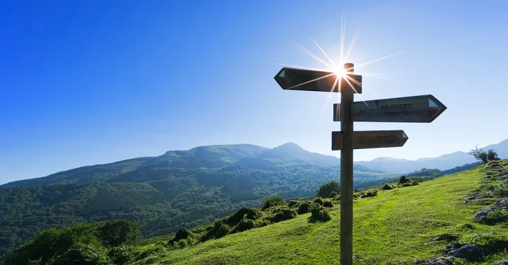 Road sign with three arrows on a mountain road