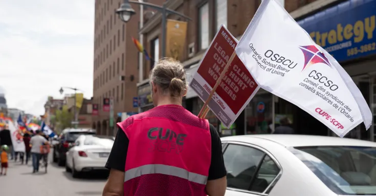 CUPE member holding OSBCU flag
