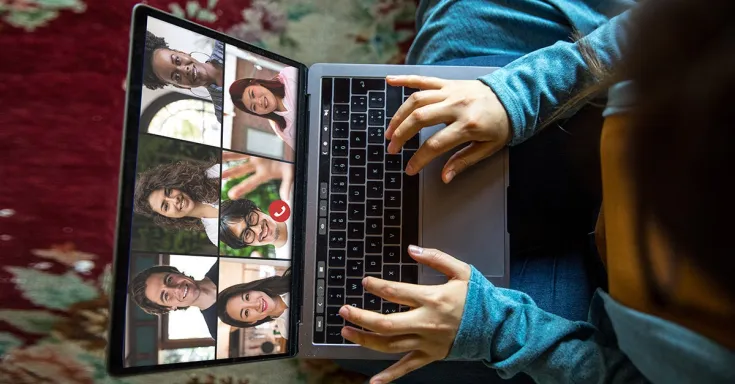 Woman at home with a computer on her lap on a video conference call