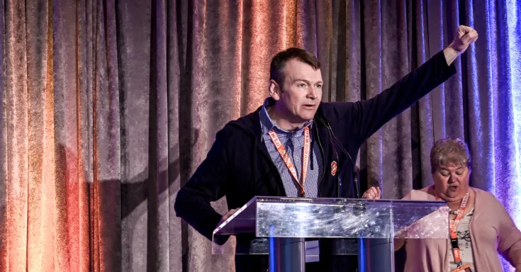 Rory Gill raises fist at CUPE AB convention