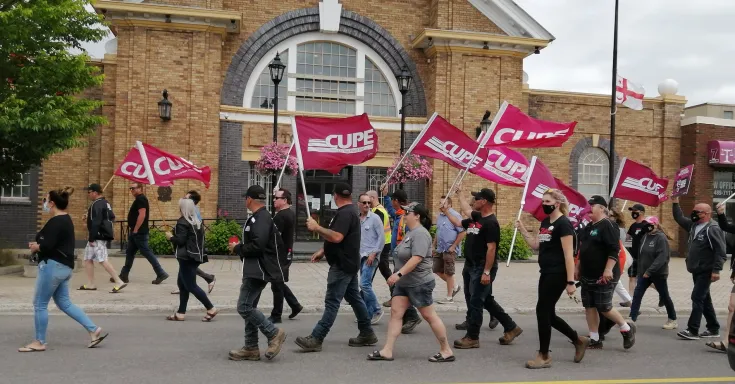 CUPE 1349 members carrying CUPE flags march in front of town hall in Grand Falls-Windsor NL